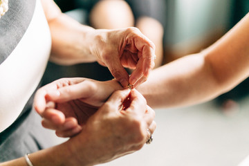 woman putting on bracelet on another woman