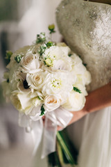 bride in wedding dress holding beautiful bouquet of flowers