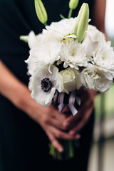 Obraz na płótnie Canvas bride in wedding dress holding beautiful bouquet of flowers