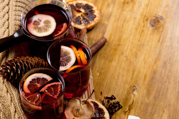 glasses of mulled wine with dry citrus and spices ,knitted sweater.