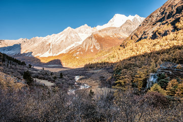 Holy mountain range with waterfall in pine forest in autumn
