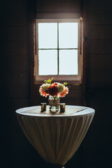 bouquet of flowers in a vase sitting on table in front of window light