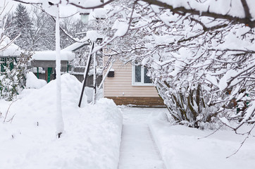 a snow-covered path leads to the house with a window