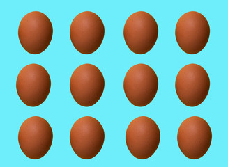 Pattern of brown chicken eggs isolated on blue pastel background. Top view. Minimalistic design