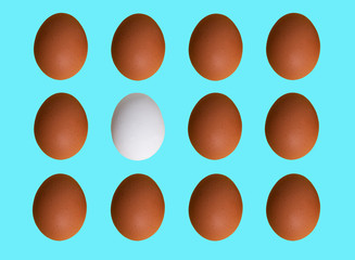 Pattern of brown white chicken eggs isolated on blue pastel background. Top view. Minimalistic design