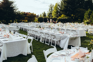 large set dining tables outside in grass for a wedding