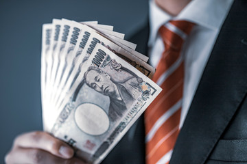 一万円札を持つビジネスマン