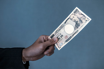 一万円札をもつ男性の手