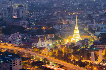 View of Wat Prayunwongsawat illuminated golden pagoda at night in Bangkok, Thailand