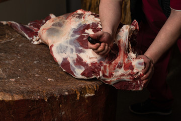 A butcher chopping beef on a wooden board