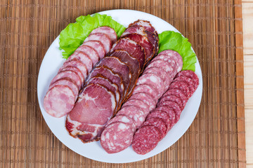 Top view of sliced dried meat and different sausages