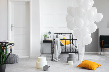 Birthday celebration in white industrial bedroom with metal bed and concrete floor