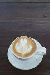 Hot coffee in white cup on wooden table