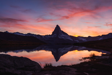 Incredible colorful sunset on Stellisee lake with Matterhorn Cervino peak in Swiss Alps. Zermatt...