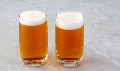 Mug of light beer with foam on the table