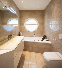 Elegant luxury bathroom with mosaic and circular window