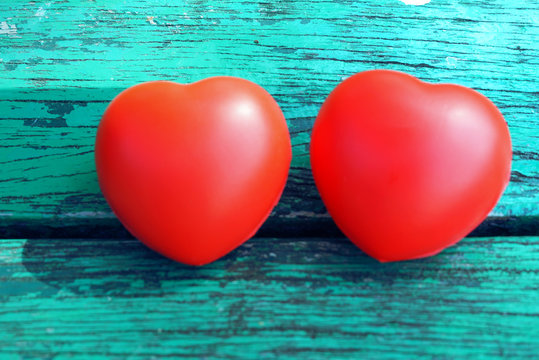  Two red hearts on old green table