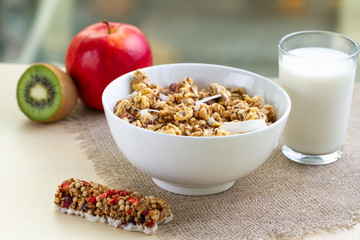 Dry breakfast cereals. Crunchy honey muesli bowl with flax seeds, cranberries and coconut and a glass of milk on a table. Healthy and fiber food. Breakfast time