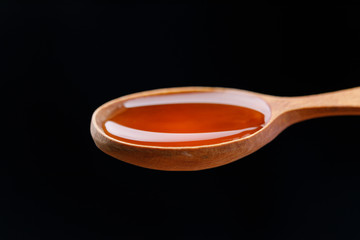A wooden spoon filled with fresh fragrant honey. Close-up.