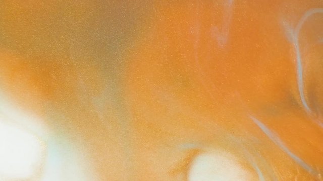 Colorful golden sand organically moves in colorful liquid