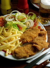 Plato combinado con tres trozos de Escalope de ternera rebozado, patatas fritas y ensalada.