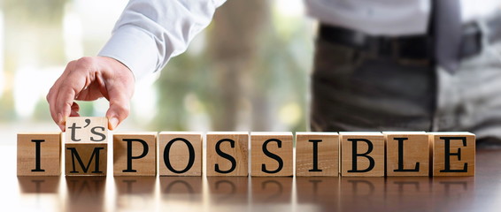 Impossible Concept With Businessman and  Wooden Blocks