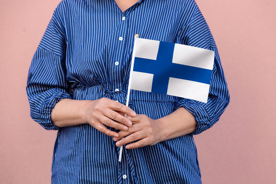 Finland flag. Close up of hands holding Finnish flag.