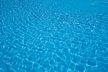 Blue pool water with sun reflections