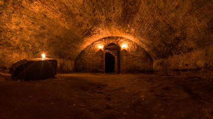 Scottish underground dungeon halls lit only by torchlight