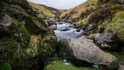 Naklejka na ściany i meble Hiking in Scottish outdoors with waterfalls, rivers and lush greenery