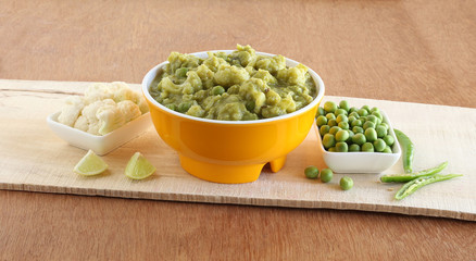 Cauliflower and peas curry, an Indian vegetarian food, which is healthy as caluliflower is a cruciferous vegetable and peas is rich in fiber, in a ceramic bowl.