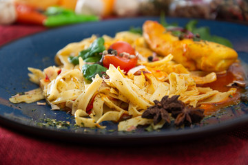 close-up of plate of pasta and chicken with lettuce