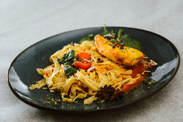 close-up of plate of pasta and chicken with lettuce