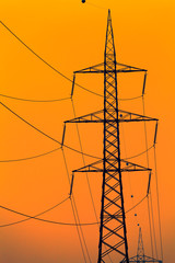 Closeup high voltage poles sunset