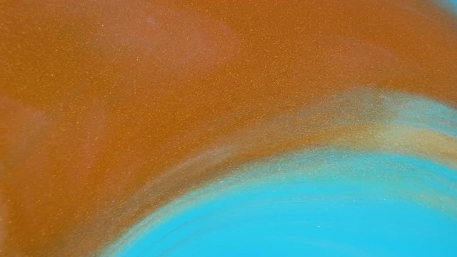 Colorful golden sand organically moves in colorful liquid