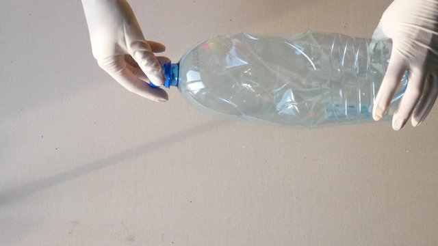 Recycling station, gloved hands sort the bottles