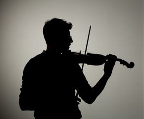 Silhouette of man playing violin