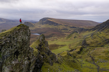 Single hiker on top of mountain in rugged volcanic landscape around Old Man of Storr, Isle of Skye, Scotland