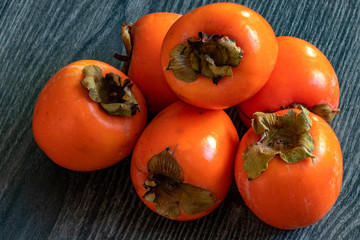 Fruits kaki en tas sur fond sombre