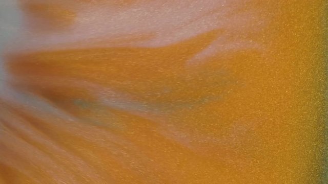 Colorful golden sand organically moves in colorful liquid
