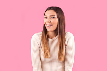 Fototapeta premium The delighted woman enjoys success and triumph in isolation on a pink wall