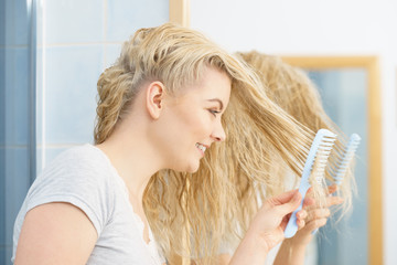 Woman brushing her wet blonde hair