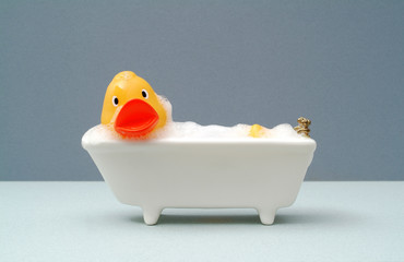 Giant rubber duck taking a bath, grey background