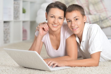 Portrait of mother and son using laptop