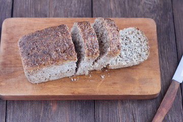 sliced whole grain bread on wooden background, selective focus