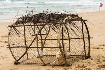 Fototapeta na wymiar Crab Trap on a beach in Thailand, sand, ocean, seaб waves