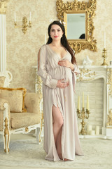 Beautiful pregnant woman posing by the fireplace