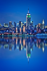 Skyline von New York mit Wasserreflexionen bei Nacht