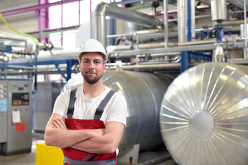 portrait of successful smiling workers/ engineers on site in an industrial factory with helmet