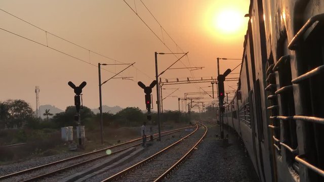 Sunset: passenger journey train rides in Indian Railways, Indian trains, all-coach train; way local traffic lights, sunset on the railway the sun's rays at sunset